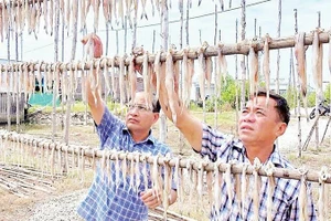 Chủ một cơ sở sản xuất kiểm tra chất lượng sản phẩm.