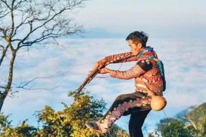 Giàng A La biểu diễn múa khèn tại điểm săn mây phục vụ du khách.