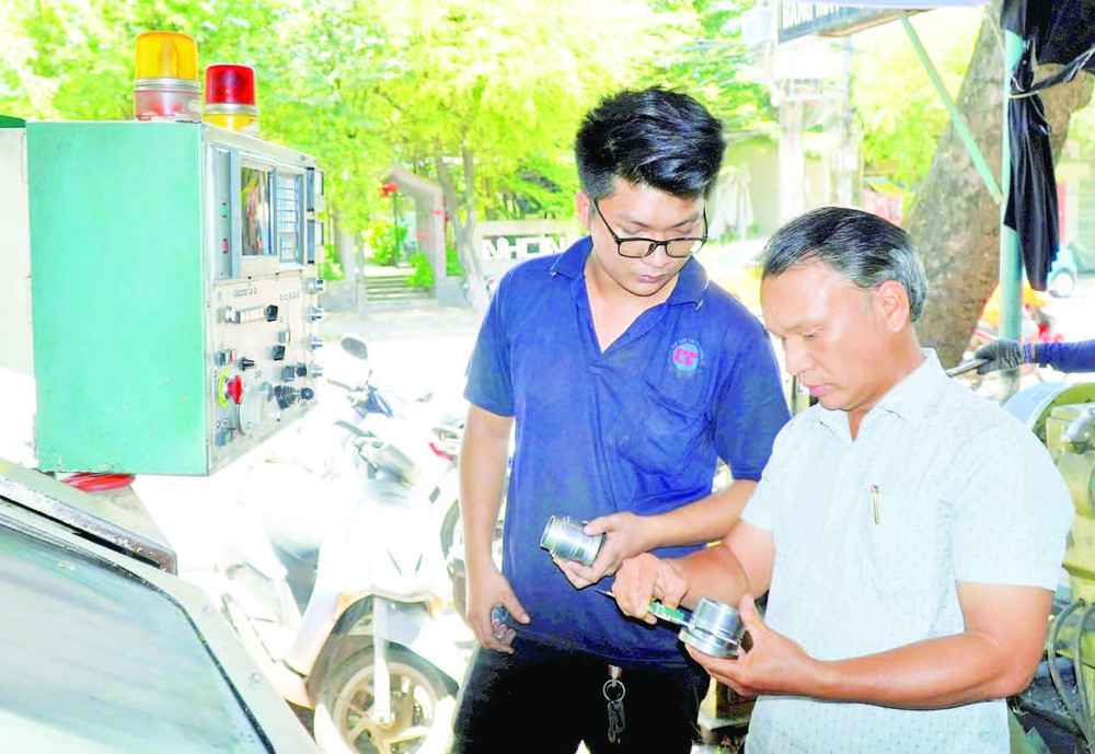 Ông Lê Thêm (bên phải) cùng cộng sự nghiên cứu sáng chế sản phẩm mới.