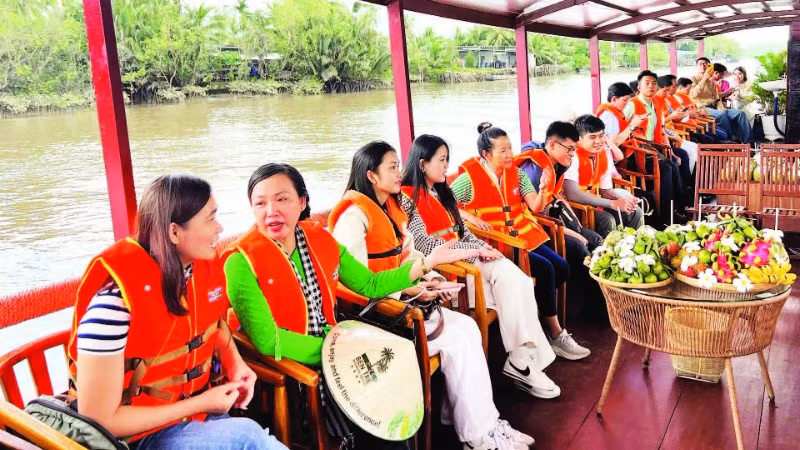 Du khách tham quan bằng tàu du lịch dọc dòng sông Thom (xã Mỏ Cày, tỉnh Vĩnh Long).