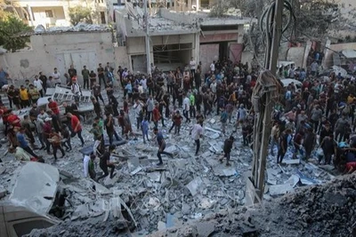 Người dân Palestine đứng giữa đống đổ nát của những tòa nhà bị phá hủy sau đòn không kích của Israel tại khu vực Al-Rimal, phía tây thành phố Gaza ngày 30/8/2025. (Ảnh: THX/TTXVN)