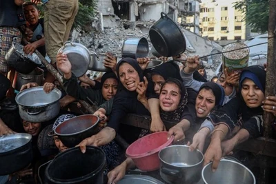 Người dân Palestine di dời khỏi chiến sự chờ nhận thực phẩm miễn phí từ một trung tâm phân phối thực phẩm ở thành phố Gaza, ngày 14/7/2025. (Ảnh: Xinhua)