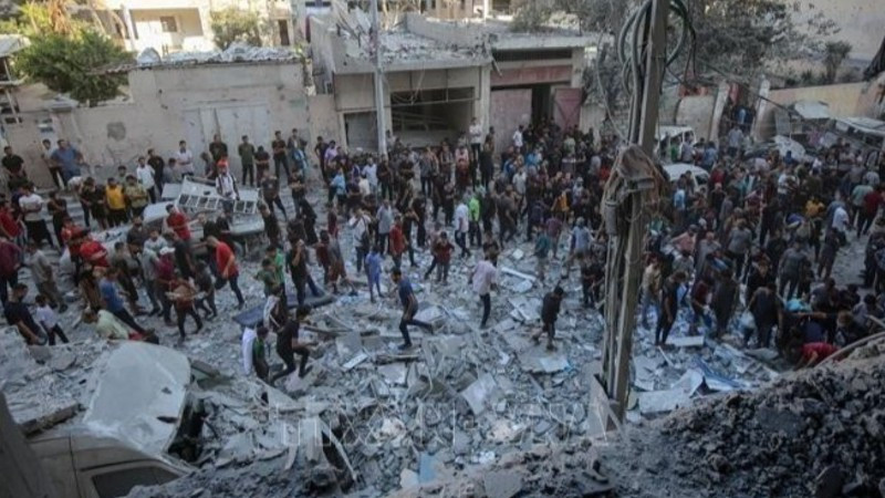 Người dân Palestine đứng giữa đống đổ nát của những tòa nhà bị phá hủy sau đòn không kích của Israel tại khu vực Al-Rimal, phía tây thành phố Gaza ngày 30/8/2025. (Ảnh: THX/TTXVN) 
