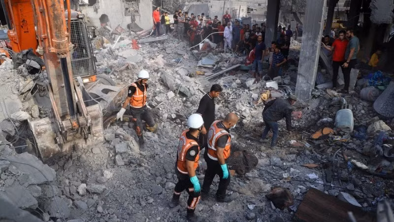 Người dân tiến hành công tác cứu hộ tại các tòa nhà bị phá hủy sau các cuộc không kích của Israel tại thành phố Khan Younis, phía Nam Dải Gaza, ngày 25/10/2023. (Ảnh: Xinhua) 