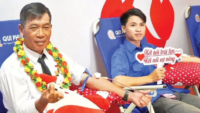 Ông Trần Minh Mến (bên trái) tham gia hiến máu tình nguyện. (Ảnh: Lê Minh)