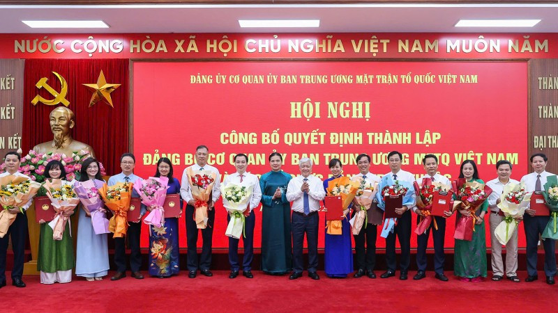Các đồng chí Đỗ Văn Chiến, Hà Thị Nga (thứ tám và chín từ phải sang) trao Quyết định, tặng hoa chúc mừng người đứng đầu các tổ chức đảng ở các đơn vị trực thuộc Cơ quan Ủy ban Trung ương Mặt trận Tổ quốc Việt Nam.