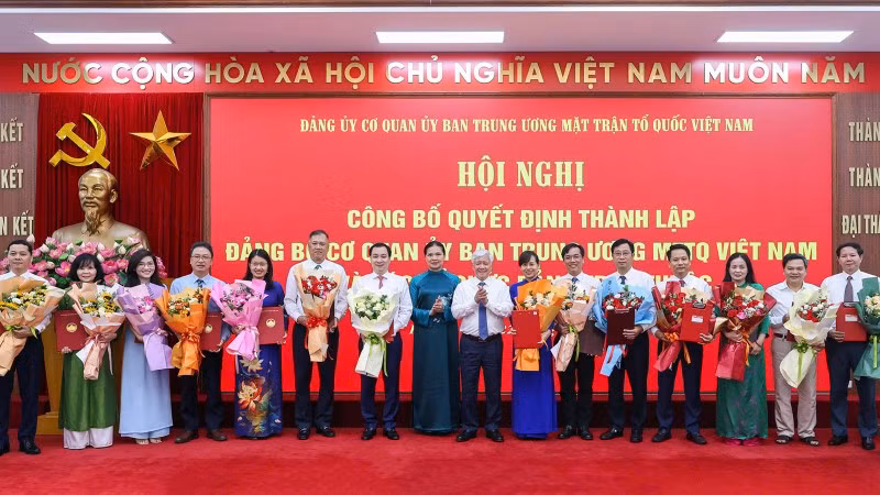 Các đồng chí Đỗ Văn Chiến, Hà Thị Nga (thứ tám và chín từ phải sang) trao Quyết định, tặng hoa chúc mừng người đứng đầu các tổ chức đảng ở các đơn vị trực thuộc Cơ quan Ủy ban Trung ương Mặt trận Tổ quốc Việt Nam.