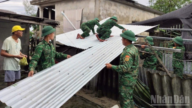 Bộ đội giúp dân lợp lại nhà tốc mái. ndo_br_vo-tien-2-2.jpg