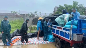 Lực lượng chức năng trợ giúp hộ dân ở xã Hoa Lộc (Thanh Hóa) di chuyển tài sản khỏi nơi có nguy cơ ngập nước. (Ảnh: nhandan.vn)