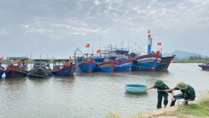 Bộ đội Biên phòng hỗ trợ người dân ứng phó với áp thấp nhiệt đới. (Ảnh: TTXVN) 