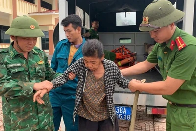 Cán bộ, chiến sĩ Đồn Biên phòng bản Giàng phối hợp đưa người dân về khu vực an toàn.