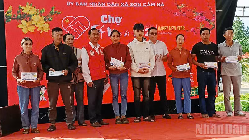 Lãnh đạo xã Sơn Cẩm Hà trao quà cho người dân.