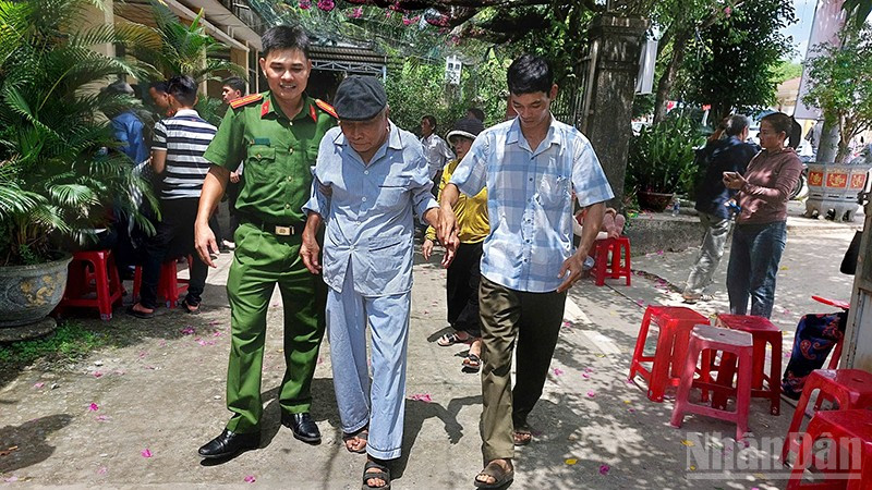 Cán bộ, chiến sĩ Công an xã Phú Ninh hỗ trợ người cao tuổi đi làm giấy tờ cá nhân.