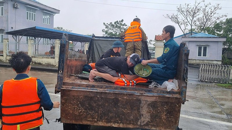 Lực lượng chức năng xã Điện Bàn Tây vận chuyển người bị nạn qua vùng ngập lũ để đi cấp cứu.