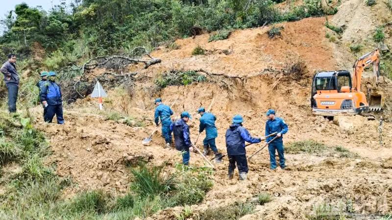 Lực lượng dân quân tự vệ xã Hùng Sơn khẩn trương dọn đất đá để khơi thông đường.