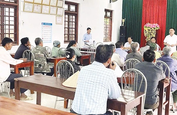 Cán bộ xã đối thoại với người dân có đất được thu hồi để triển khai dự án điện.