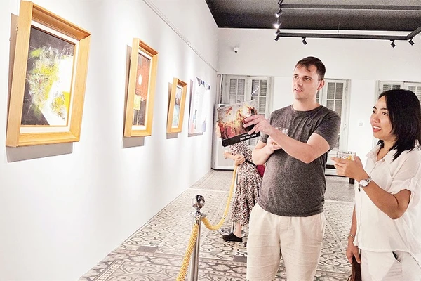 Khách xem tranh trong trưng bày chuyên đề "Trở về" tại Bảo tàng Mỹ thuật Thành phố Hồ Chí Minh. (Ảnh ĐÔNG A)