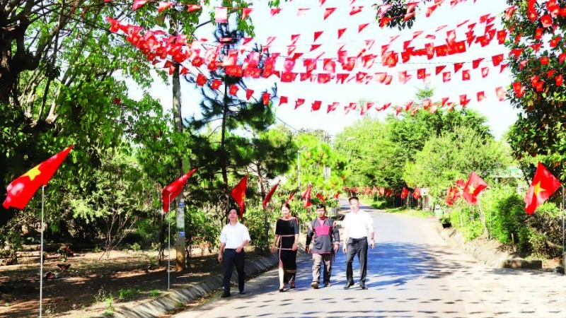 Các tuyến đường dẫn vào buôn Tuôr, xã Hòa Phú rợp đỏ màu cờ Tổ quốc chào mừng Đại hội XIV của Đảng.