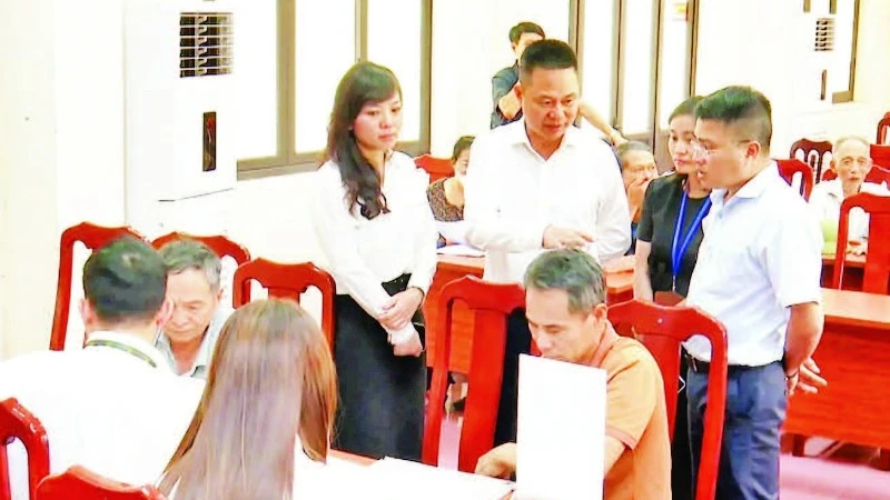 Lãnh đạo xã Phú Xuyên kiểm tra công tác hỗ trợ người dân làm thủ tục cấp giấy chứng nhận quyền sử dụng đất. (Ảnh CÔNG TÂM)