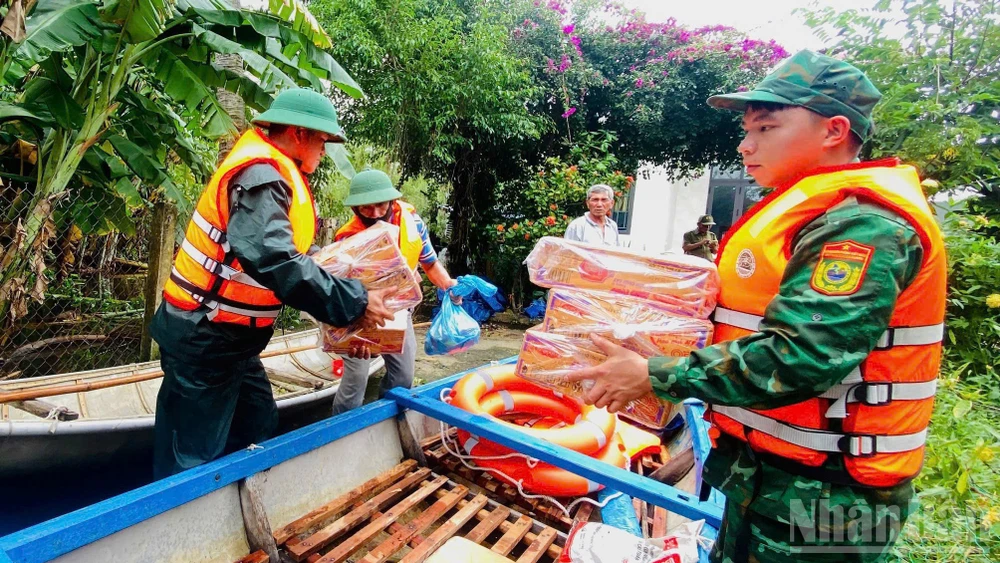 Cán bộ, chiến sĩ Đồn Biên phòng Bình Hải và Hải đội 2 (Bộ đội Biên phòng tỉnh Quảng Ngãi) vận chuyển nhu yếu phẩm hỗ trợ người dân thôn Châu Me, xã Đông Sơn.