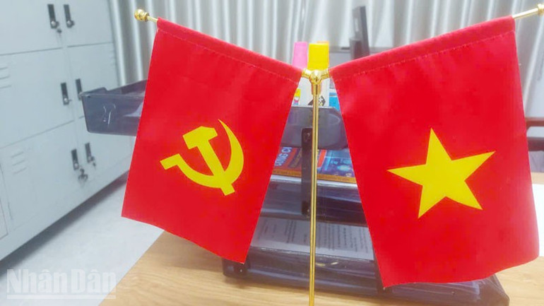 Bà Thu còn may cờ Đảng, cờ Tổ quốc trang trí bàn làm việc. ndo_bl_8.jpg