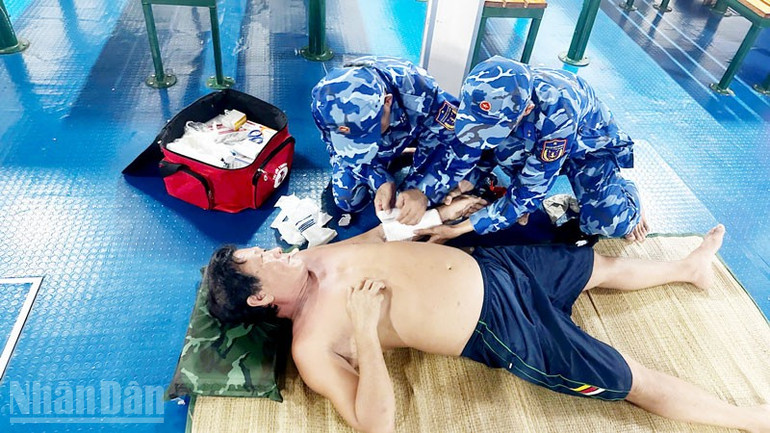 Tổ Quân y tiến hành thăm khám, băng bó vết thương cho nạn nhân. ndo_bl_2.jpg