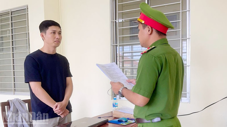 Đối tượng Võ Quốc Việt (bên trái) nghe Công an tống đạt quyết định khởi tố vụ án. ndo_bl_2.jpg