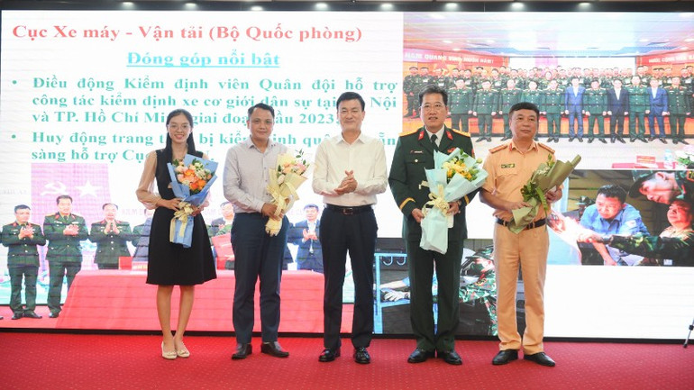Cục trưởng Cục Đăng kiểm Việt Nam Nguyễn Chiến Thắng tặng hoa cho các đồng chí đại diện Cục Cảnh sát giao thông (Bộ Công an) và Cục Xe máy-Vận tải (Bộ Quốc phòng). (Ảnh: THẾ ĐẠI) gap-mat-cuc-dang-kiem-1740-1639.jpg