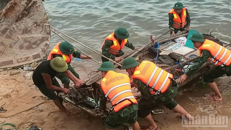 Cán bộ, chiến sĩ Đồn Biên phòng Bạch Long Vĩ giúp ngư dân cẩu, kéo phương tiện lên bờ tránh trú bão. ndo_br_bao-11-2-440.jpg
