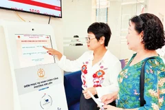 Hướng dẫn người dân lấy số thứ tự để thực hiện thủ tục hành chính tại Điểm tiếp nhận, phục vụ hành chính công phường Kim Liên (Hà Nội). (Ảnh: NGUYÊN BẢO)