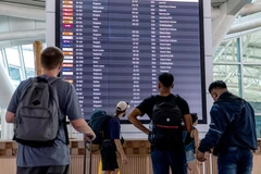 Hành khách xem thông tin trên bảng điện tử tại sân bay quốc tế I Gusti Ngurah Rai ở Bali, Indonesia. (Ảnh: XINHUA)