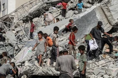 Người dân Palestine tại khu vực một tòa tháp bị phá hủy sau cuộc không kích của Israel vào thành phố Gaza ngày 6/9/2025. (Ảnh: XINHUA).