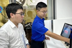 Cán bộ Trung tâm Đăng ký giao dịch, tài sản (thuộc Cục Đăng ký giao dịch bảo đảm và Bồi thường nhà nước, Bộ Tư pháp) hướng dẫn người dân làm hồ sơ trên Hệ thống đăng ký trực tuyến.