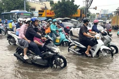 Nước dâng sớm, rút chậm trên đường Phạm Hữu Lầu, kéo dài từ cầu Phước Long đến đường Huỳnh Tấn Phát (Thành phố Hồ Chí Minh) khiến các phương tiện di chuyển chậm, khó khăn. (Ảnh: Hương Giang/TTXVN)