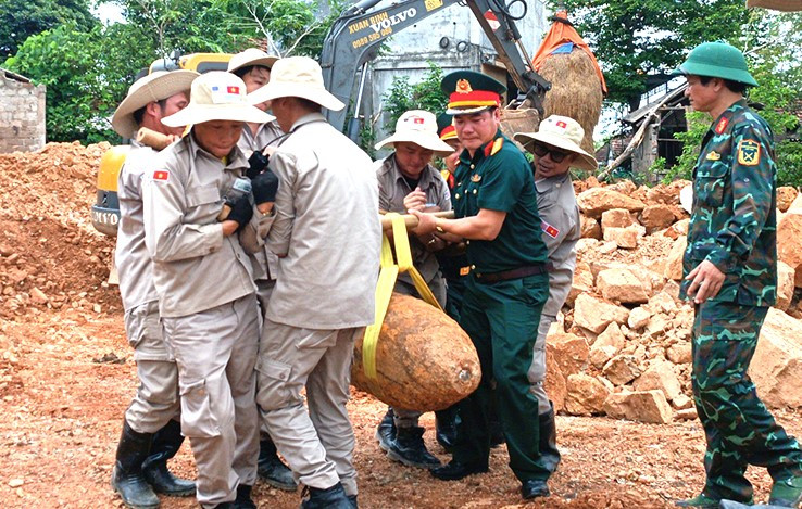 Các lực lượng phối hợp di dời, xử lý quả bom còn sót lại sau chiến tranh. (Ảnh: LA)