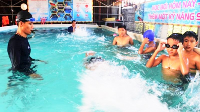 Giáo viên ở Lệ Thủy, Quảng Bình dạy bơi cho học sinh. (Ảnh: Hương Giang)