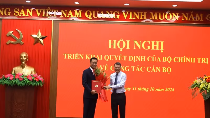 Đồng chí Lê Minh Hưng, Ủy viên Bộ Chính trị, Bí thư Trung ương Đảng, Trưởng Ban Tổ chức Trung ương trao quyết định, tặng hoa cho đồng chí Lê Ngọc Quang.