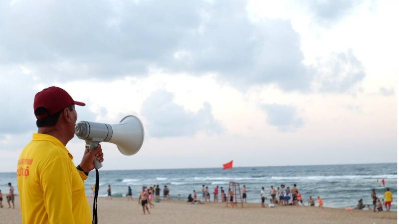 Thành viên đội cứu hộ trên bãi biển Nhật Lệ nhắc nhở du khách tuân thủ quy định để tắm biển an toàn. (Ảnh: minh họa)