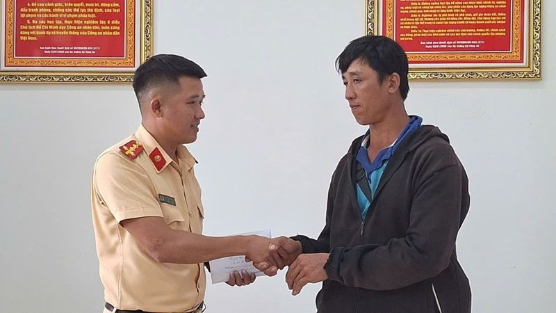 Đại úy Kiều Thanh Hùng, cán bộ Đội Cảnh sát giao thông đường bộ số 2, Phòng Cảnh sát giao thông, Công an tỉnh Đắk Lắk bàn giao số tiền 29 triệu đồng cho anh Phan Ngọc Hùng. (Ảnh: CTV)