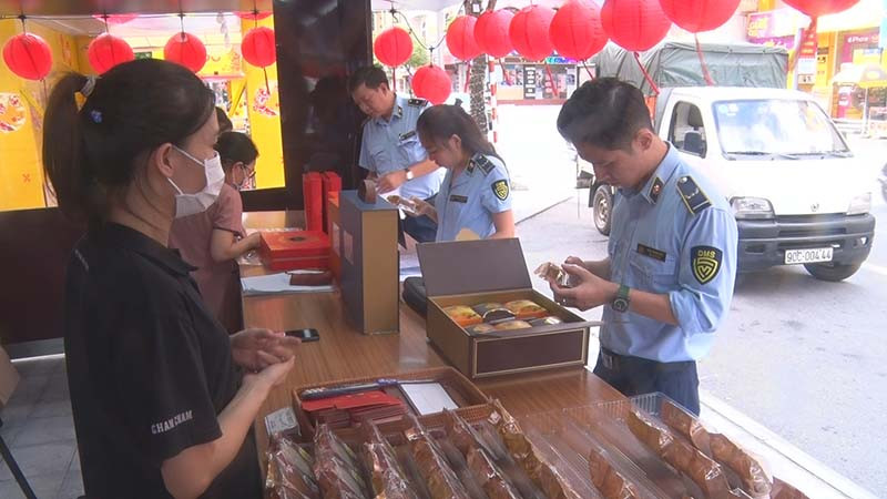Cán bộ Cục Quản lý thị trường tỉnh Hà Nam kiểm tra nguồn gốc, xuất xứ của các loại bánh trung thu được bày bán trên thị trường.