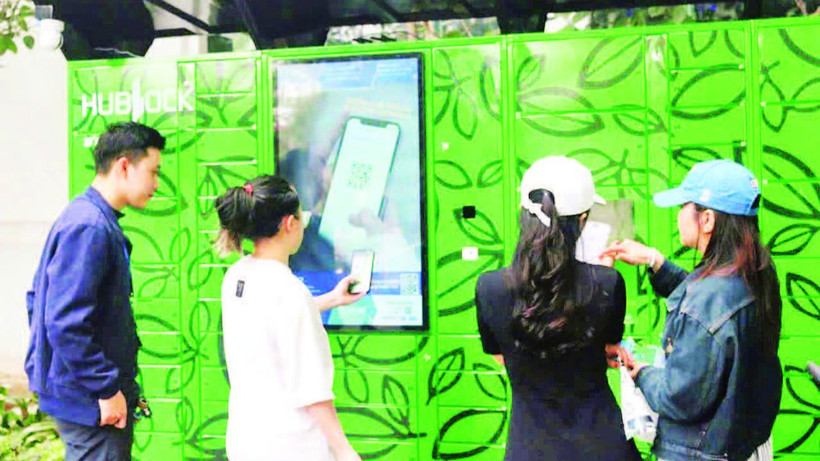 Người dân sử dụng dịch vụ giao-nhận đồ tại tủ thông minh Hublock đặt tại Khu đô thị Times City, Hà Nội. (Ảnh HOÀNG HƯNG)