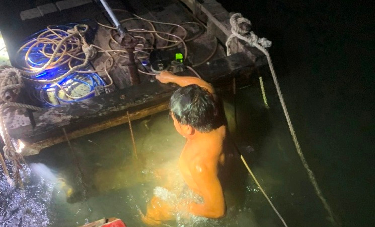 Một đối tượng lặn dò nguồn cát để khai thác cát trái phép bị lực lượng công an phát hiện.