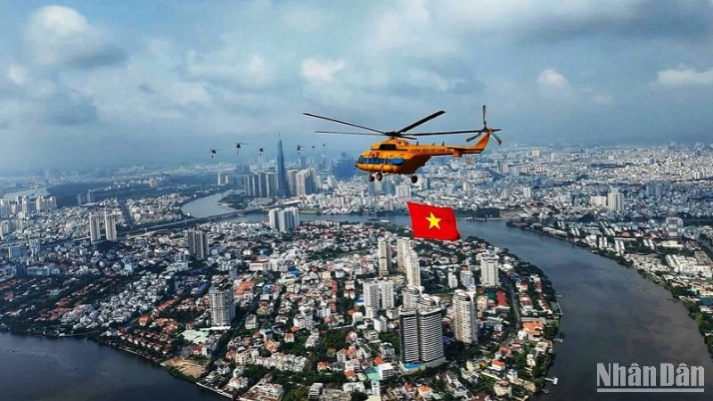 Trực thăng tập luyện bay kéo cờ trên bầu trời thành phố Hồ Chí Minh. (Ảnh: Khiếu Minh)