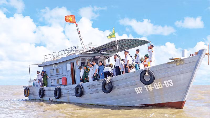 Tàu của Bộ đội Biên phòng Cà Mau chở nhân chứng lịch sử đến thăm cửa biển Vàm Lũng.
