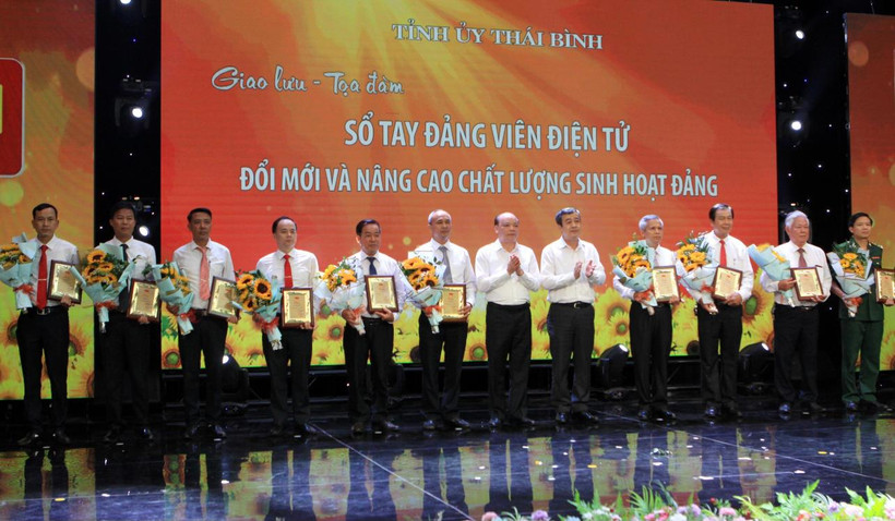 Đồng chí Ngô Đông Hải, Bí thư Tỉnh ủy Thái Bình (thứ 5 từ phải qua) trao biểu trưng vinh danh những tập thể, cá nhân triển khai tốt “Sổ tay đảng viên điện tử”.