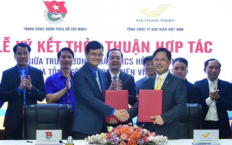 Hàng đầu, từ trái qua: các đồng chí Bùi Quang Huy, Ủy viên dự khuyết Trung ương Đảng, Bí thư thứ nhất Trung ương Đoàn; Chu Quang Hào, Tổng Giám đốc Tổng Công ty Bưu điện Việt Nam trao thỏa thuận hợp tác giữa 2 bên tại buổi lễ.