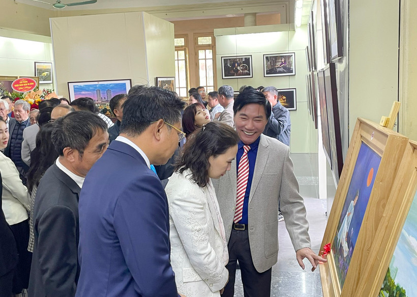 Họa sĩ Nguyễn Văn Trường (thứ 3 bên phải) giới thiệu tranh tại triển lãm.