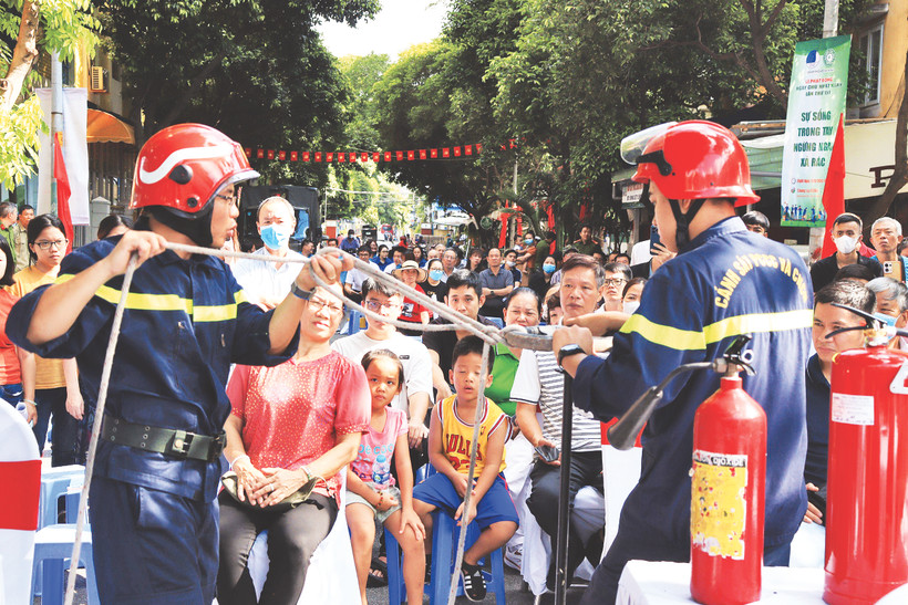 Người dân quận Tân Bình (TP Hồ Chí Minh) được các cán bộ, chiến sĩ phòng cháy, chữa cháy và cứu nạn, cứu hộ hướng dẫn cách thoát hiểm bằng dây thừng khi xảy ra cháy nổ. Ảnh | THẾ ANH