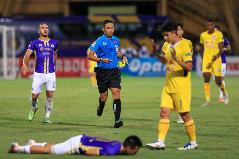 Trọng tài Ngô Duy Lân rút thẻ vàng với Hồng Duy sau pha tranh chấp. Ảnh: Minh Dân. 