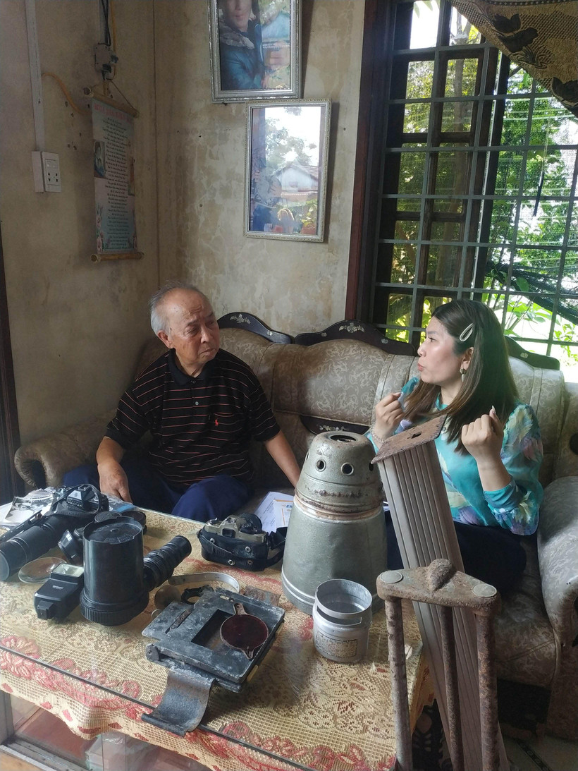 Nghệ sĩ nhiếp ảnh Hồ Sỹ Sô trò chuyện với cán bộ Bảo tàng Báo chí Việt Nam.